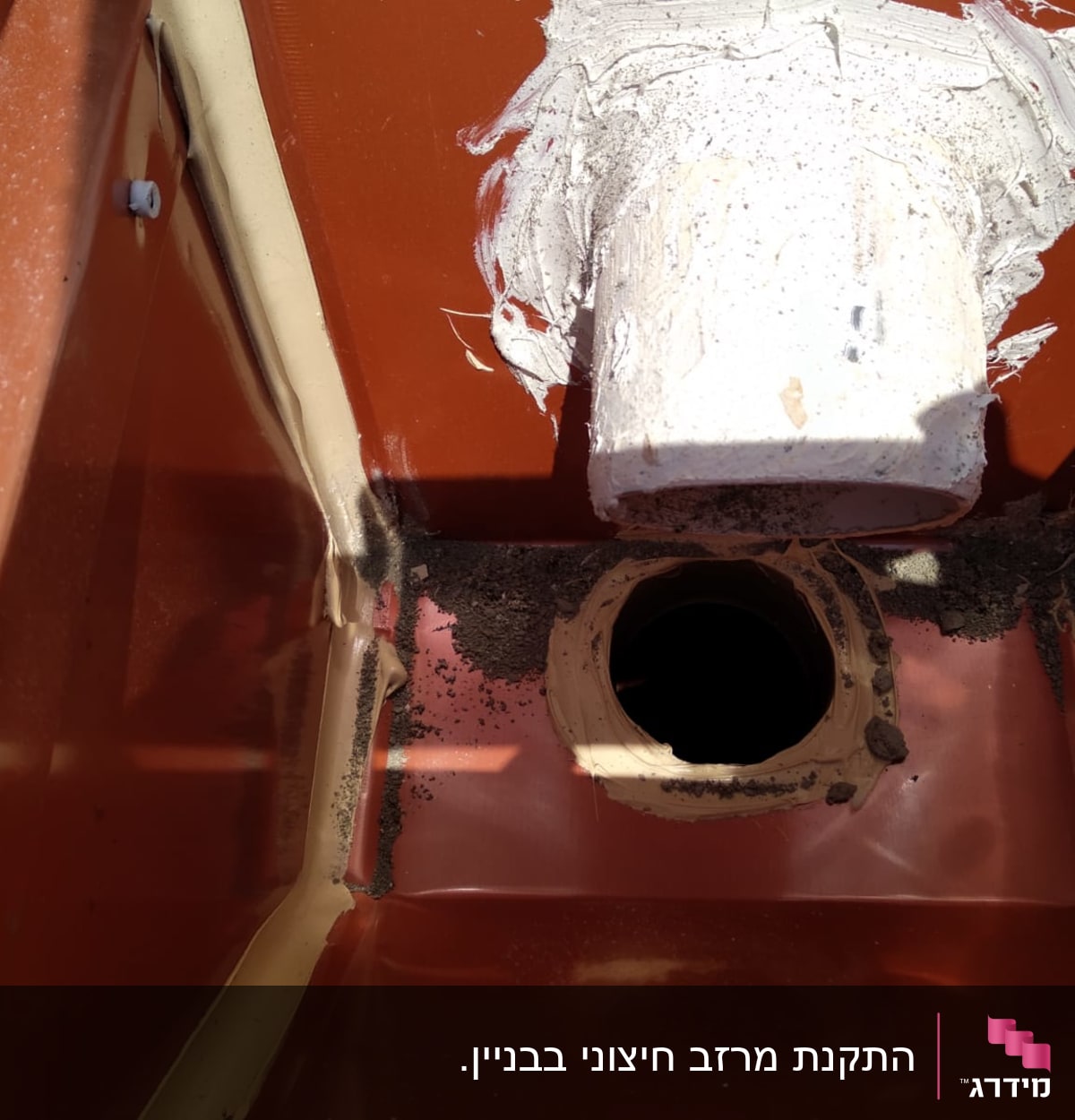 צינור לבן עם חומר איטום על גג אדום